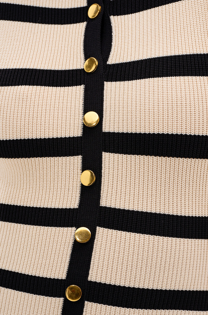 Close-up of the KAREN STRIPE KNIT MIDI DRESS, showcasing beige and black horizontal stripes, shiny gold buttons, and a stretchy knit fabric.