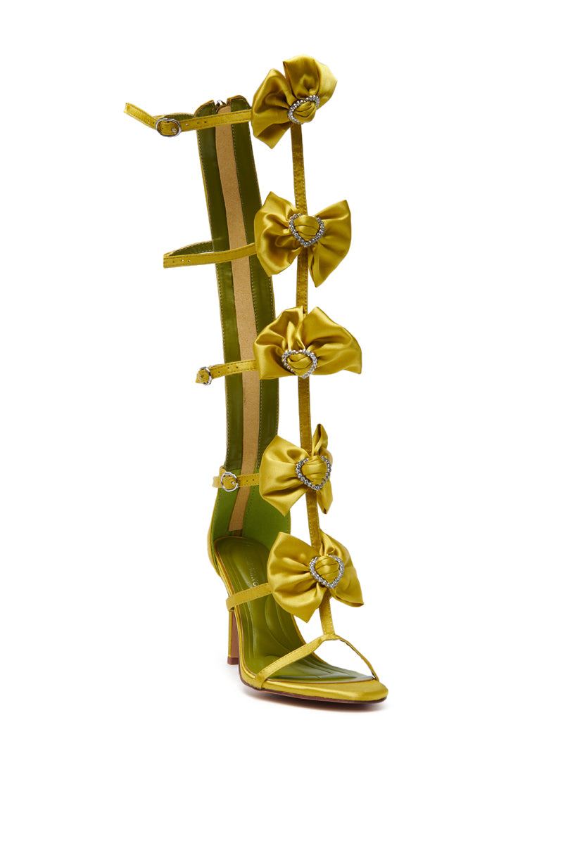 The AZALEA WANG AERIN LIME BOW EMBELLISHED GLADIATOR STILETTO SANDAL is a tall, lime green satin sandal with bow accents and jeweled centers. It features an open toe, block heel, and comfort cushion insole for all-day wear. 4