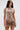 A woman in the FAR FROM BASIC SEQUIN MINI DRESS, featuring shiny rose gold sequins, shell embellishments, a high neckline, and flared skirt, holds a small round purse against a plain light background.
