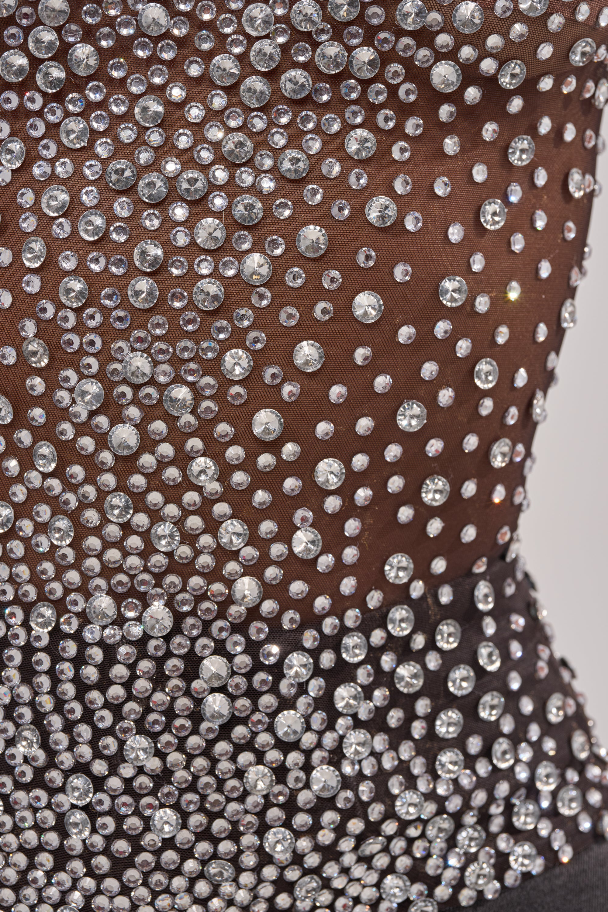 Close-up of the ALL YEAR ROUND SHEER RHINESTONE TOP, featuring a black mesh mock-neck covered in shimmering rhinestones of different sizes for a dense, glamorous after-dark look. 7