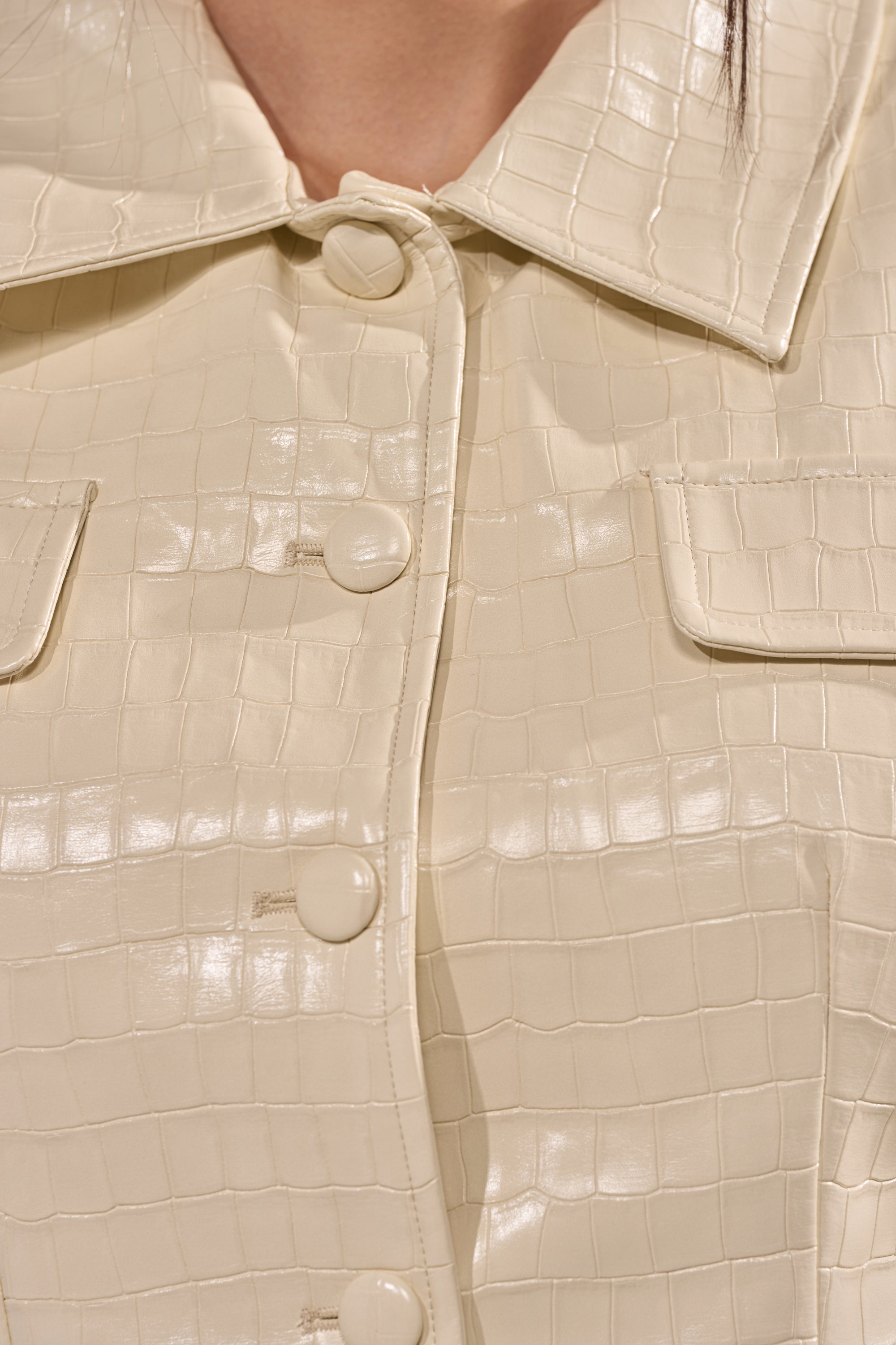Close-up of the STANDING ON BUSINESS PU MINI DRESS in beige, featuring crocodile-embossed faux leather, large buttons, flap pockets, and detailed stitching that highlights its textured finish. 10