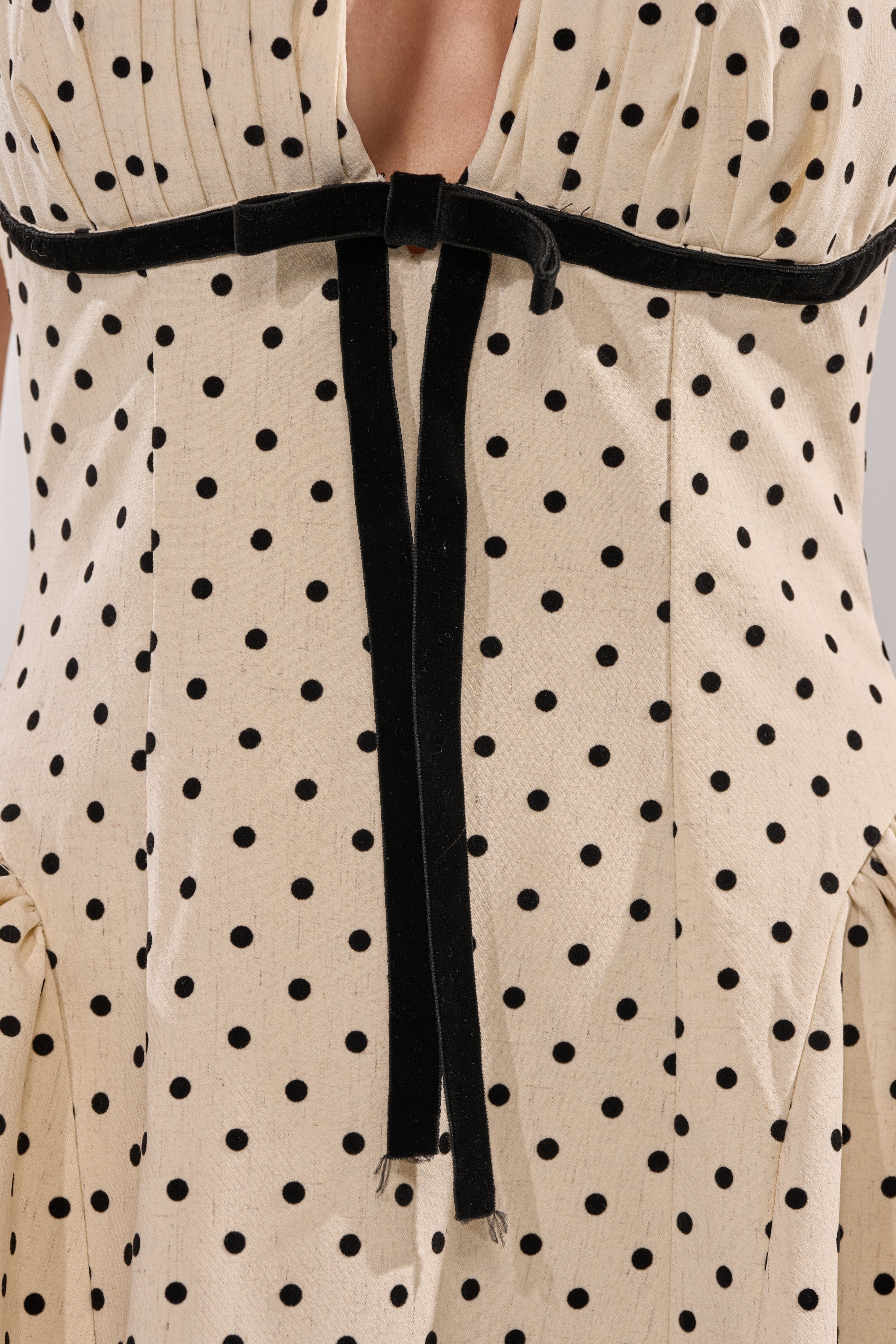 Close-up of the SUNDAY AFFAIR MAXI DRESS, a vintage-inspired cream maxi with black polka dots, featuring a velvet ribbon at the waist and a keyhole back opening. 6