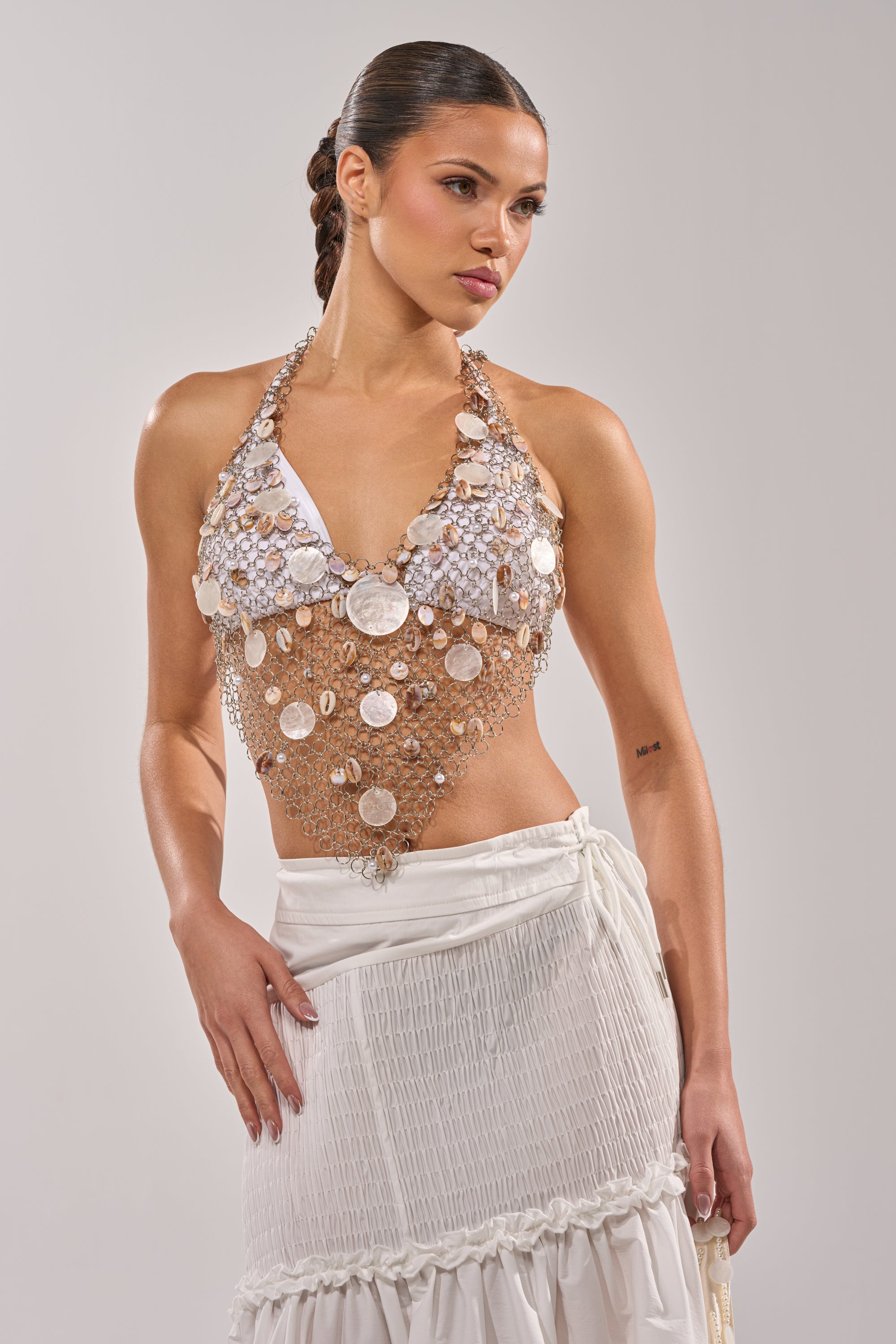 A woman wearing a white dress and the SALLY SELLS SEASHELLS CROCHET HALTER TOP. 1