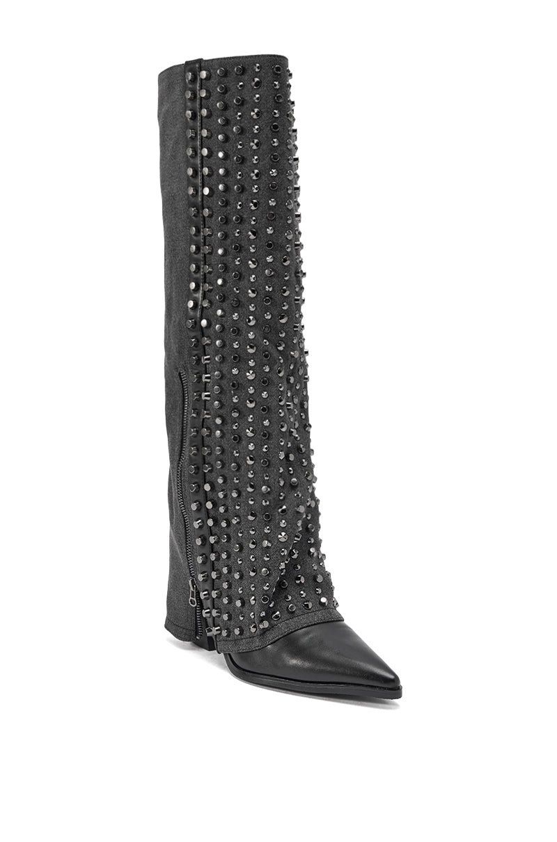 The AZALEA WANG AGUSTUE BLACK STUDDED WESTERN BOOT is a tall black boot with a pointed toe, featuring rows of silver studs along the front and side, plus a slight slouch in the shaft for classic western flair.