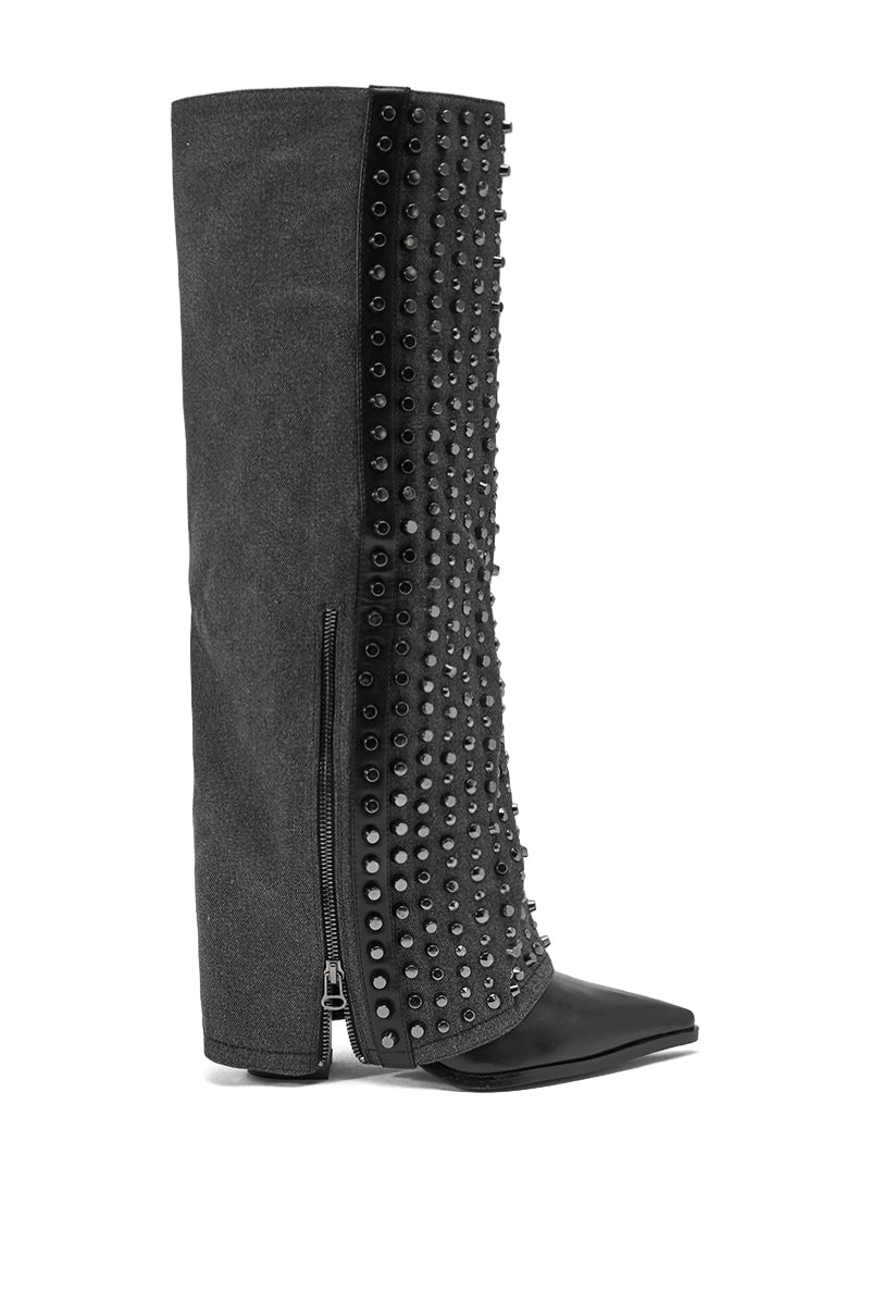 The AZALEA WANG AGUSTUE BLACK STUDDED WESTERN BOOT features a tall silhouette, block heel, side zipper, pointed toe, and black studs on the front. Matte fabric contrasts with a shiny toe and studded panel for a bold western style.