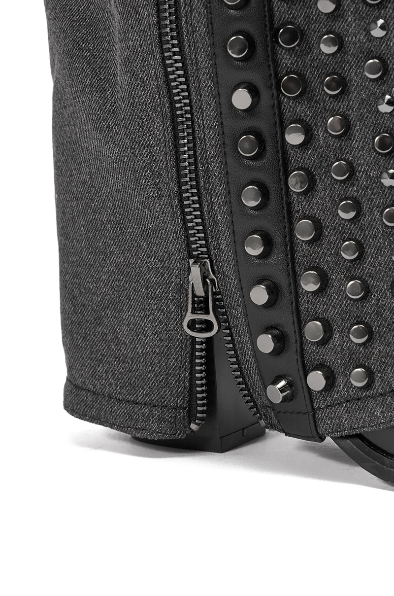 Close-up of a dark gray fabric bag with a black zipper and shiny metallic studs, mirroring the bold studded details of the AZALEA WANG AGUSTUE BLACK STUDDED WESTERN BOOT.