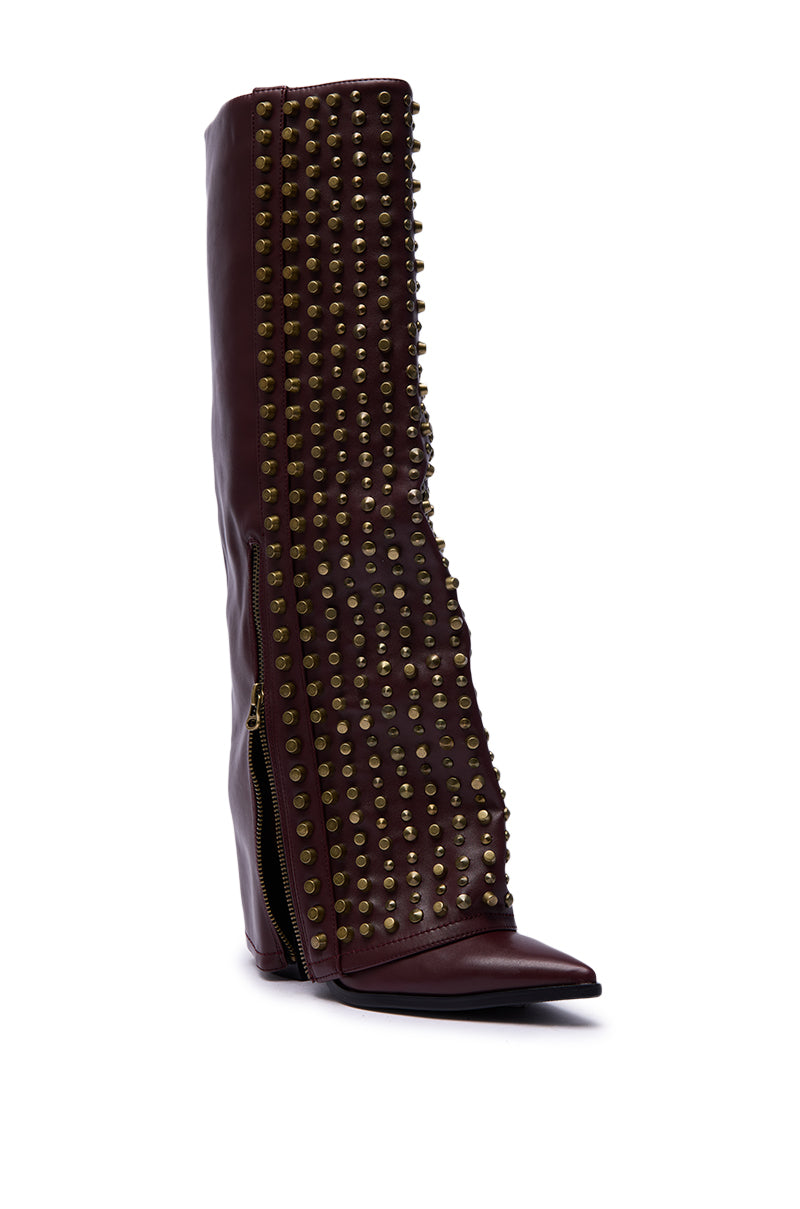 The AZALEA WANG AGUSTUE Burgundy Studded Western Boot is a tall, knee-high boot with gold studs, a pointed toe, visible side zipper, and high wedge heel in dark brown leather.