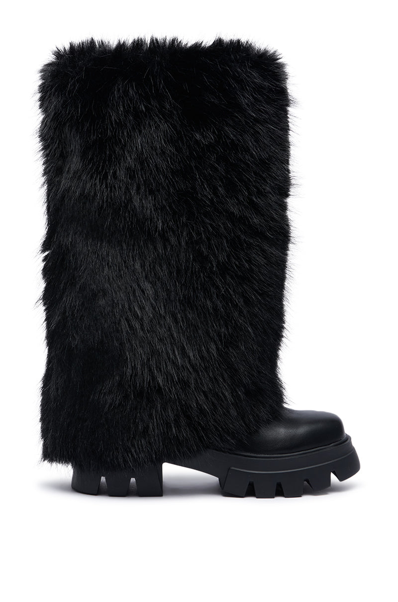 The AZALEA WANG AHSOKA BLACK FUR FLATFORM BOOT is a sleek mid-calf, black boot with a chunky rubber sole featuring deep treads and a textured faux fur upper, perfect for making a bold statement in winter fashion.