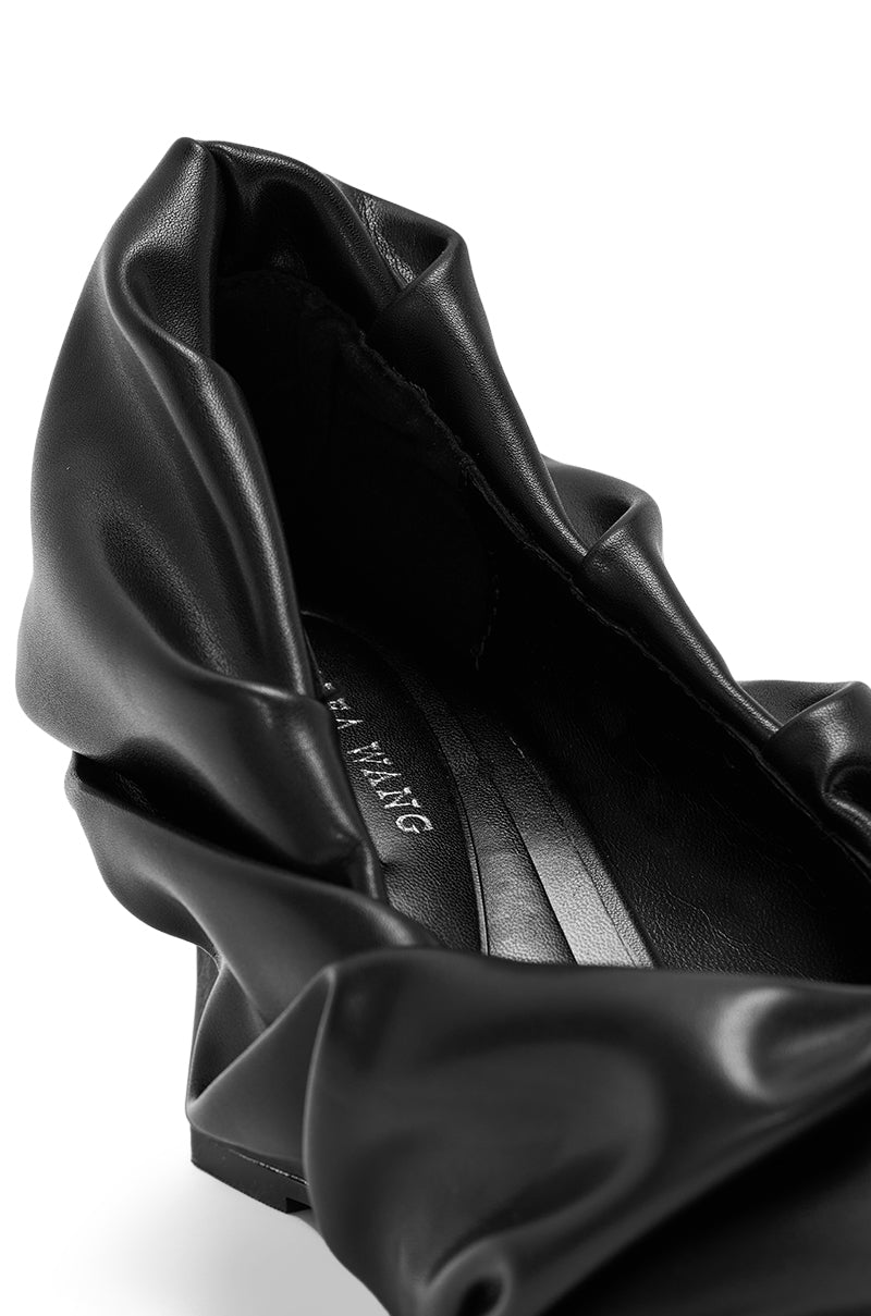 Close-up of the AZALEA WANG AICHA BLACK RUCHED WEDGE PUMP in black faux leather with ruched detailing, a pointed toe, smooth insole, and wedge heel, set against a white background.