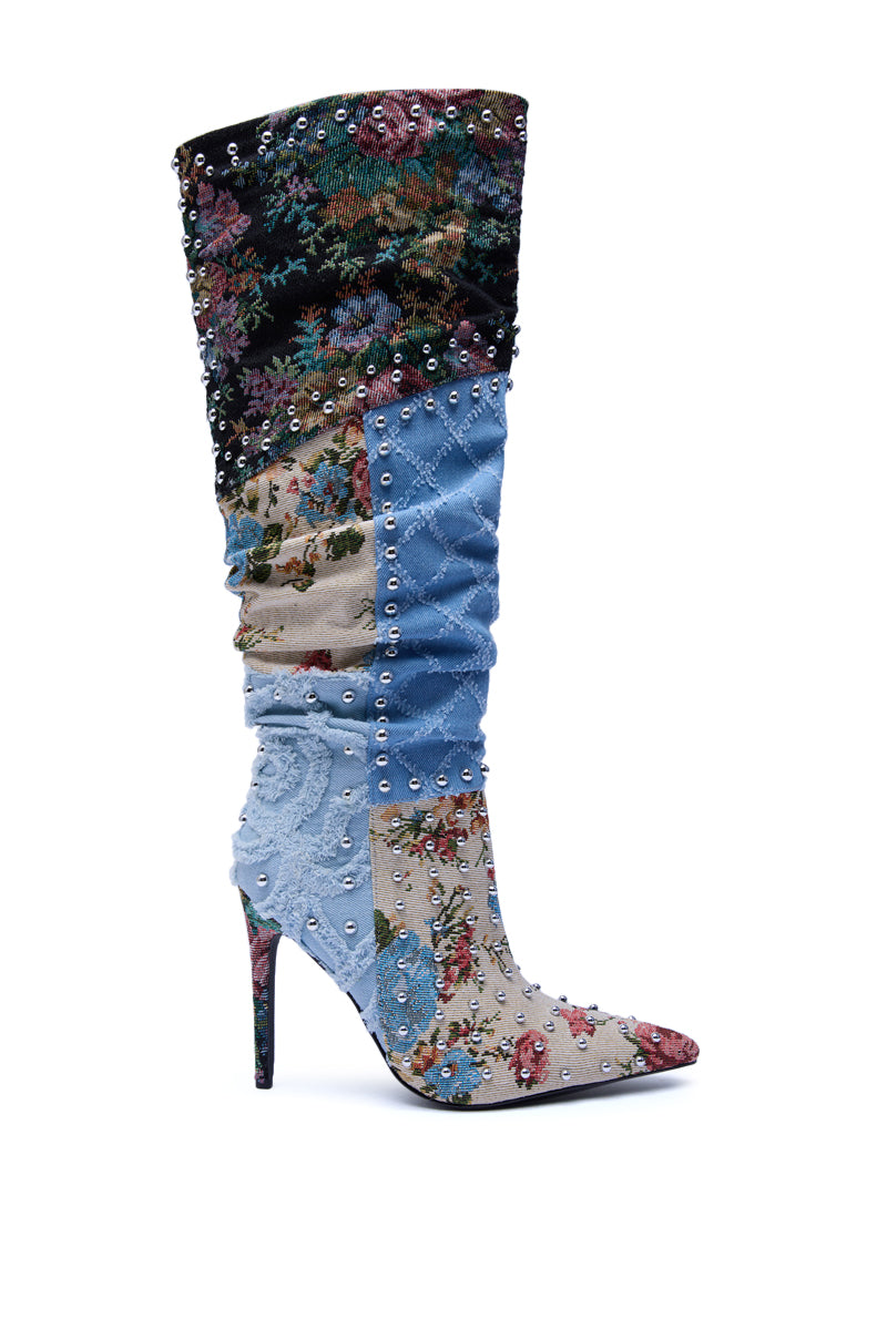 The AZALEA WANG AILA DENIM MULTI STUDDED POINTED TOE STILETTO BOOT is a knee-high denim boot with patchwork floral tapestry, denim, and velvet details, silver studs all over, and a sleek stiletto heel for standout style.