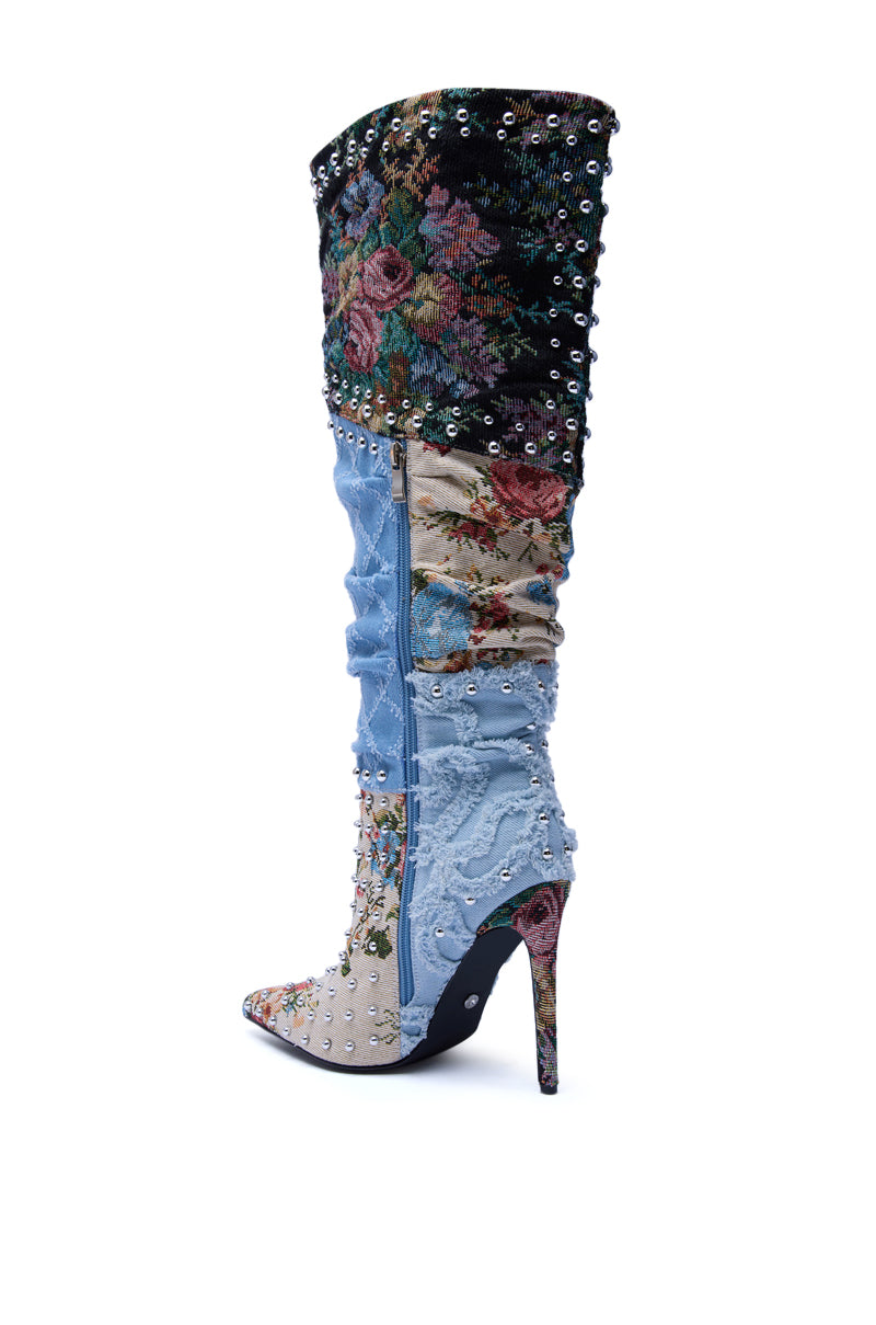 The AZALEA WANG AILA DENIM MULTI STUDDED POINTED TOE STILETTO BOOT is a knee-high boot with floral tapestry, light blue denim, embroidered flowers, metallic studs, a pointed toe, tall stiletto heel, and side zipper.