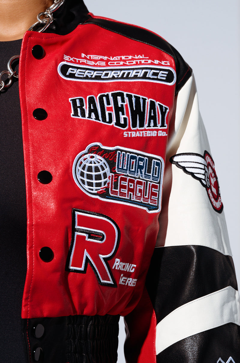 Close-up of the MOTOR SPORT RACER BOMBER, a red and black racer-inspired jacket adorned with multiple embroidered patches. The patches feature text such as "Raceway Strategic Co.," "World League," "Racing Series," and "Performance." The jacket is detailed with black buttons, white sleeve sections, and embodies the classic Motor Sport Racer Bomber style. 5