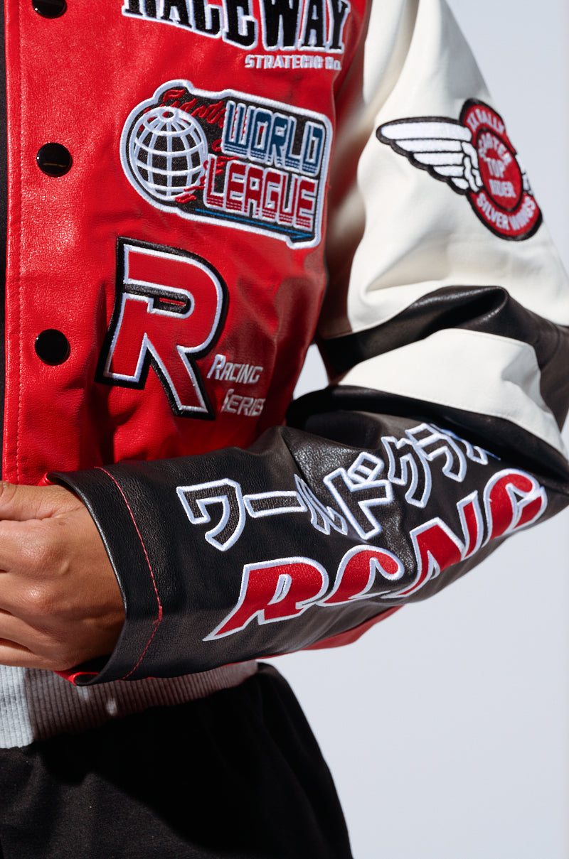 A close-up of a person wearing the MOTOR SPORT RACER BOMBER, a red and white racing-themed jacket adorned with various racer-inspired embroidered patches and logos, including text like “Racing Series,” “World League," "Raceway," and Japanese characters on the sleeve. The jacket is designed with snap buttons and a faux leather base. 6