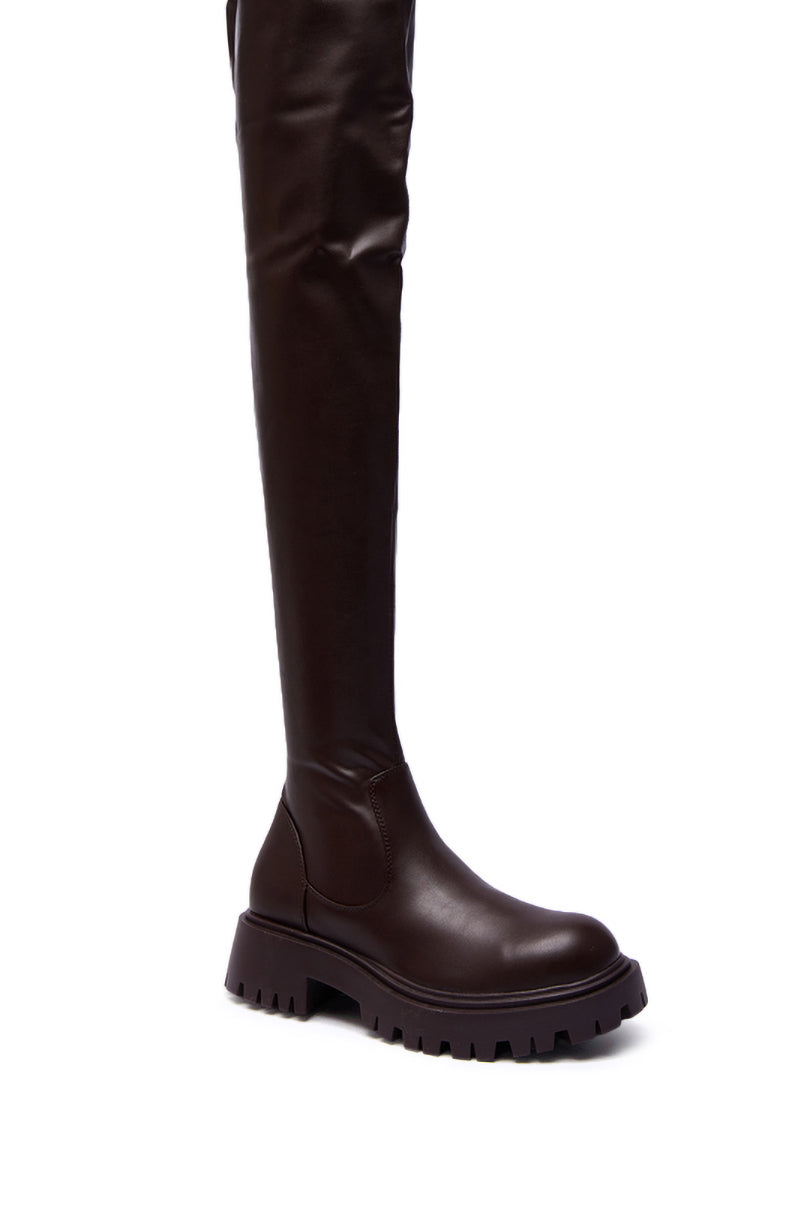 The AZALEA WANG AJUNA Chocolate Four Way Stretch PU Flat Boot is a tall, dark brown thigh-high boot with a chunky rubber sole, rounded toe, and smooth, shiny faux leather finish.
