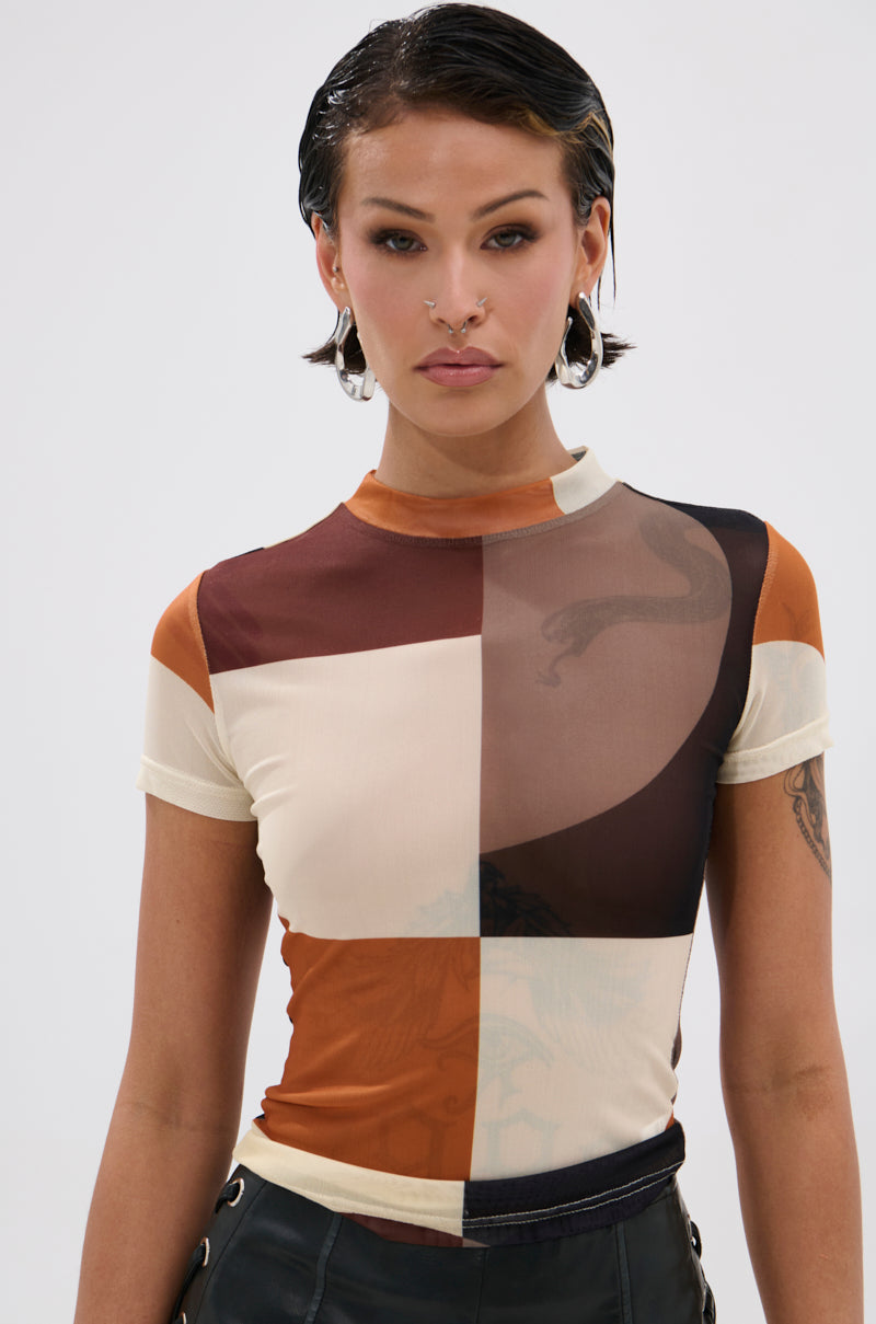 A person with short, dark, wet-look hair and facial piercings wears the SYMBOLISM MESH SHORT SLEEVE TEE, featuring a large geometric color-block pattern in brown, tan, cream, and black for a retro look.
