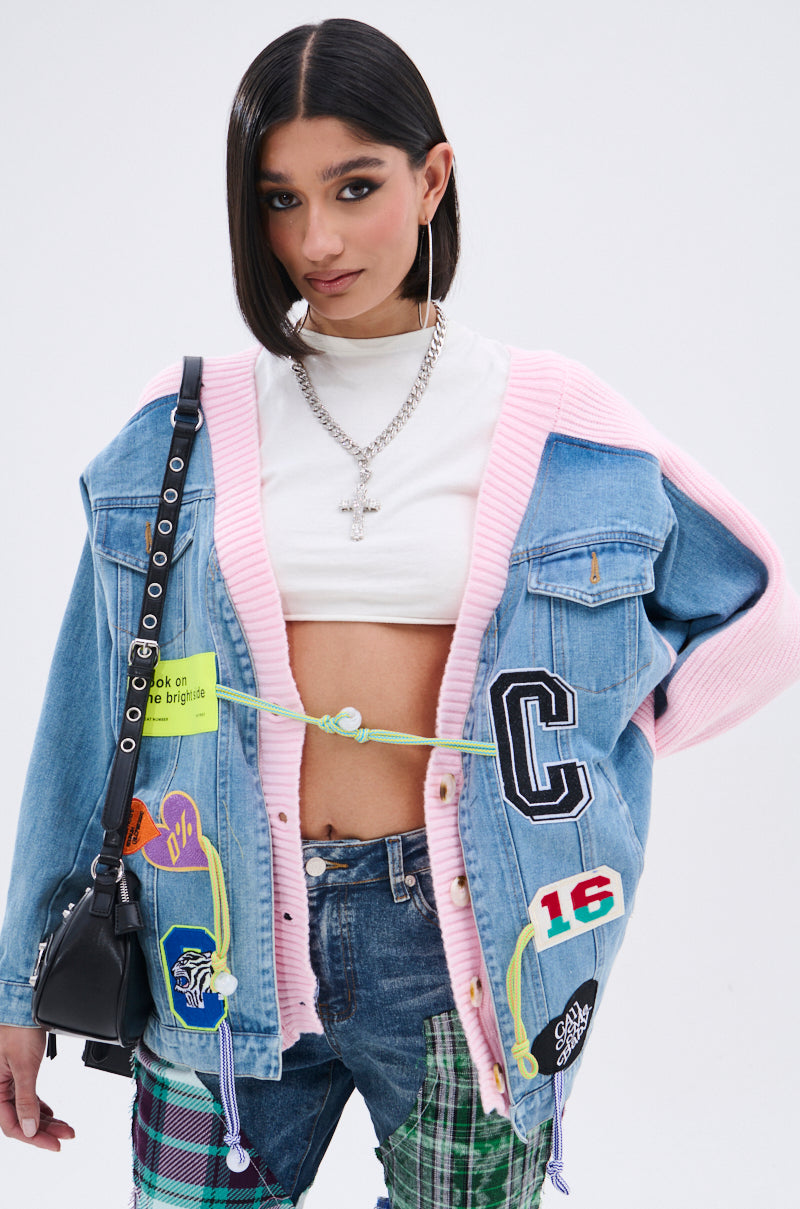 A young woman models a SURGICAL SPLICED CARDIGAN with knit fabric, styled with a cropped white turtleneck, patchwork jeans, hoop earrings, chunky chain necklace, and a black crossbody bag. 3