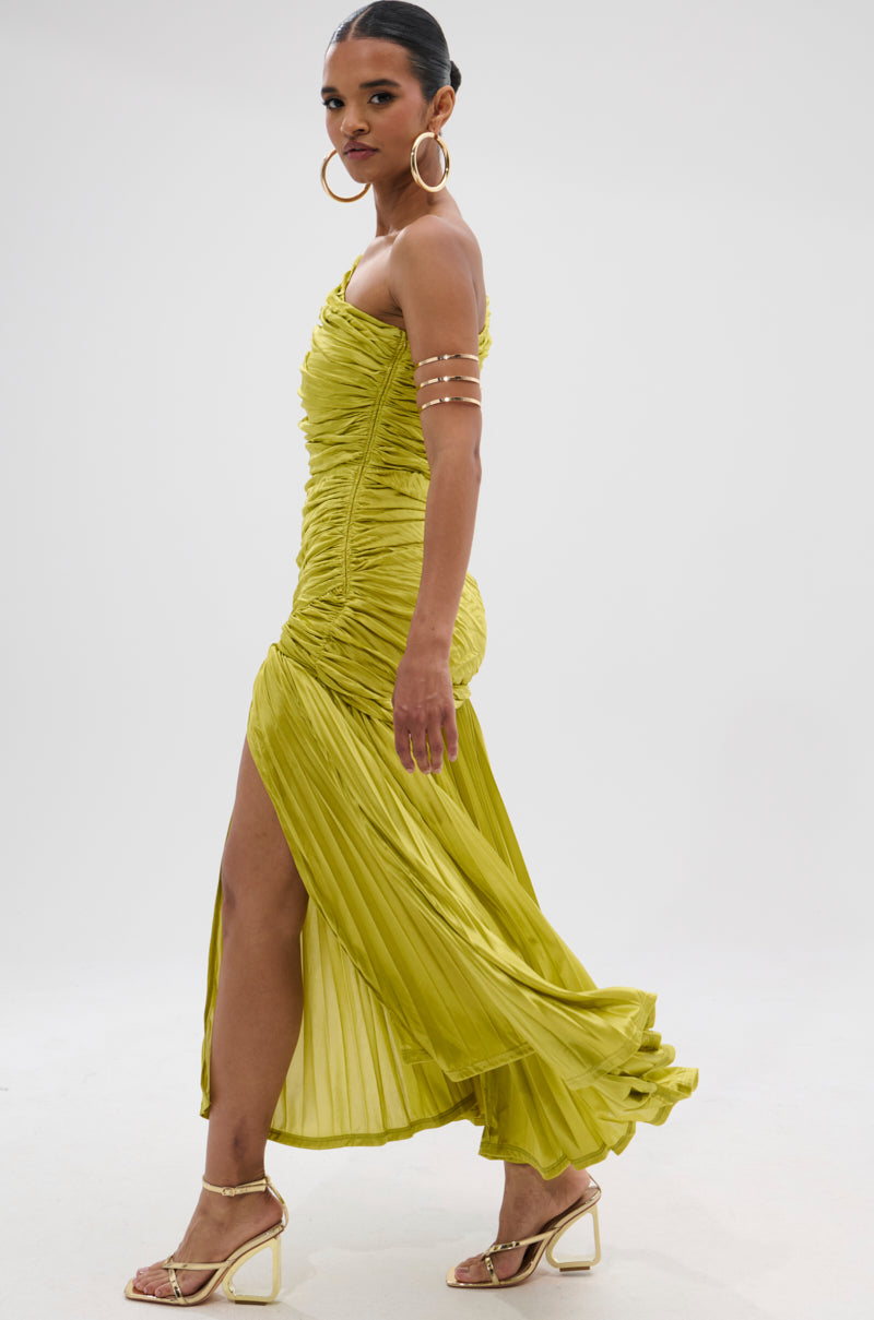 A woman walks confidently in the LIFE OF THE PARTY SATIN MIDI DRESS—a bright yellow, ruched midi dress with a high slit—paired with gold heels and large hoop earrings against a plain white background.
