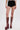 A person stands against a plain white background, showcasing only the lower half while wearing the TOO HOT TO HANDLE LACE HOT SHORT and tall, burgundy lace-up platform boots with high heels.