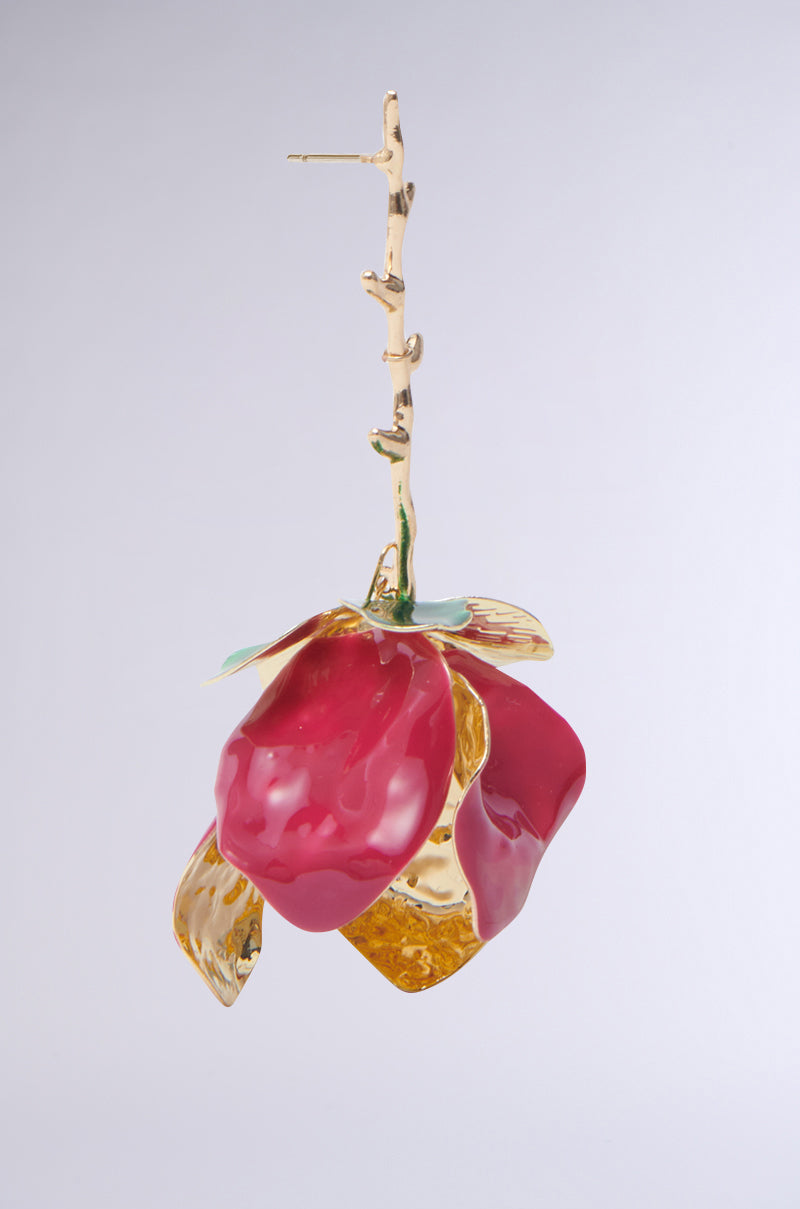 The IN BLOOM EARRING showcases a rose dangle silhouette on a slender branched rod. Glossy red petals with gold and green accents adorn a faux gold metallic base, creating an elegant contrast against the neutral background. 4