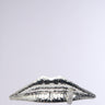 The LIP SERVICE RING features a metallic sculpture of lips with a finger gesture suggesting silence. Its textured, faux silver metallic surface stands out against a plain light gray background.