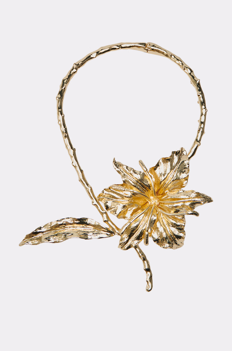 The IM THE ONE FLOWER NECKLACE is a gold choker with a bold, textured flower and leaf on an organic-shaped band—perfect for those who love standout, oversized floral jewelry. 0