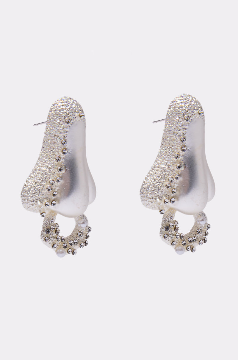 The SMELLS LIKE FASHION EARRING features metallic, textured statement earrings shaped like noses with circular beaded hoops hanging from each nostril—perfect bold accessories set against a plain white background. 4
