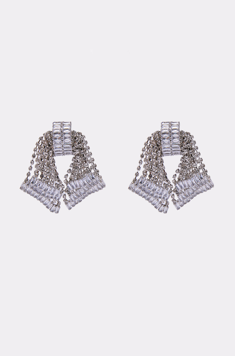 The ELI EARRING features cascading silver chains with small rectangular crystals in a fan-like, geometric design that dazzles against a plain white background.