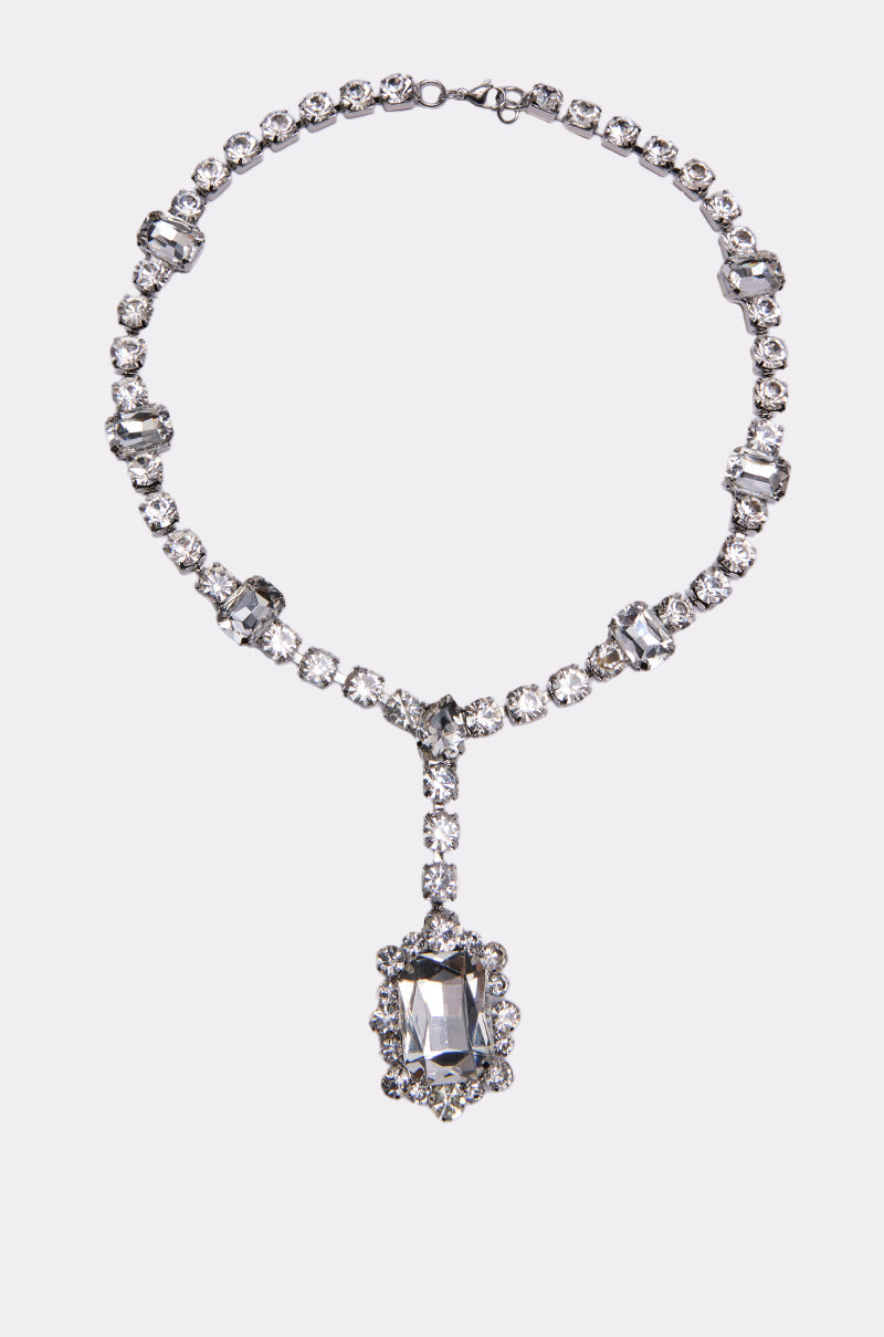 The FOR THE RECORD BLING NECKLACE features a strand of round stones with rectangular accents and a bold rectangular pendant framed by smaller diamonds, all crafted in sparkling white metal. 0