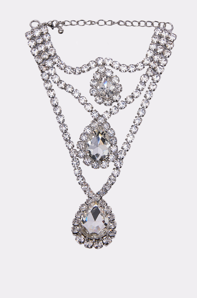 The ELSIE BLING RING HAND PANJA features three large teardrop-shaped clear gemstones surrounded by rhinestones, linked with sparkling silver chains—ideal to pair with your favorite statement jewelry or crystal bracelet.