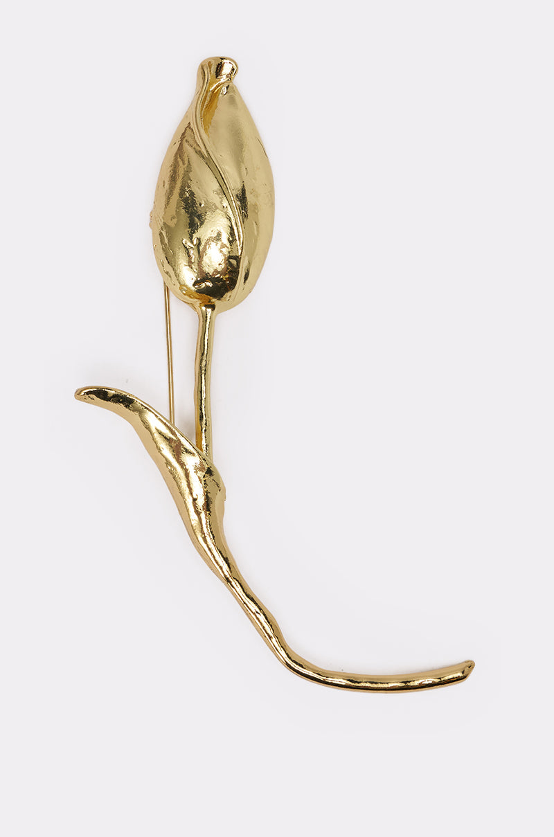 The SPRINGY BROOCH is a gold-tone tulip bud brooch featuring a smooth, shiny finish and a curved stem, displayed against a plain white background. 1