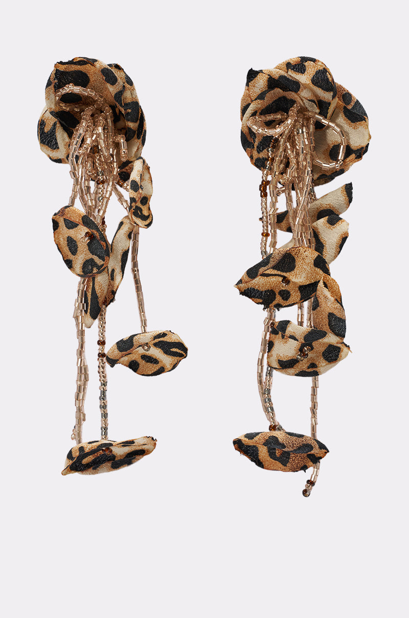 The LEAH EARRING is a pair of statement earrings with fabric flower shapes and bead strands in leopard print and gold tones, shown on a white background. 0