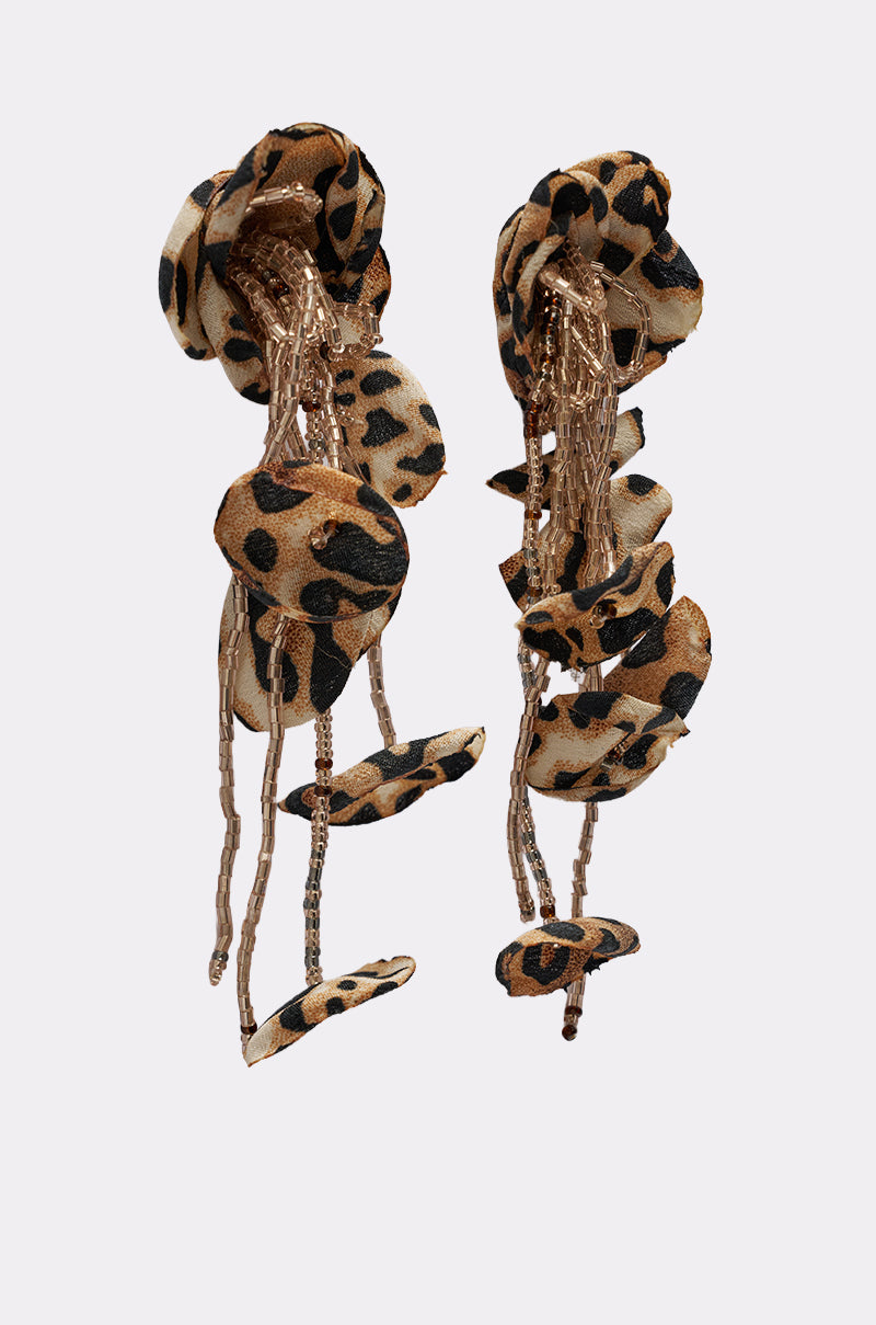 The LEAH EARRING features leopard print fabric ruffles and long gold chains in an asymmetrical, cascading design—statement earrings that pop against a light grey background. 2