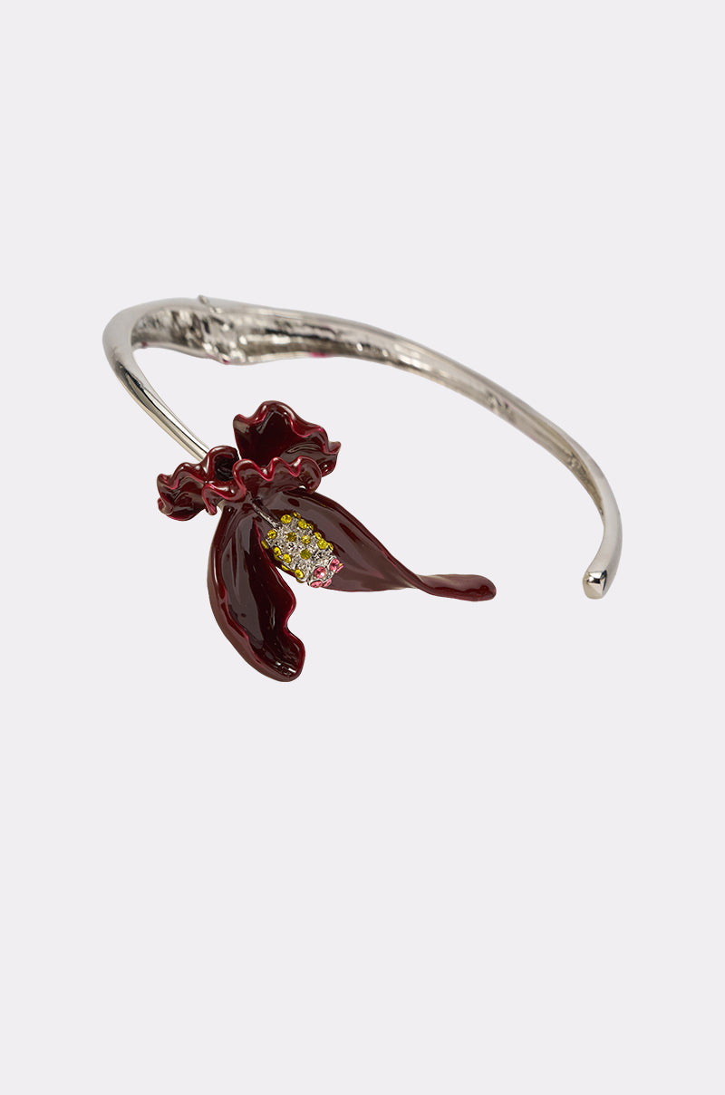 The FULL BLOOM NECKLACE features a detailed dark red enamel flower with yellow accents, reminiscent of a floral torque design, showcased against a plain white background. 3