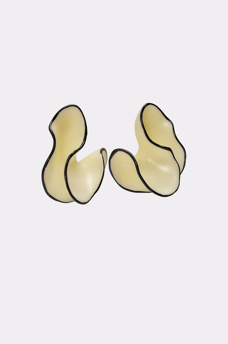 The ITS MY WORLD EARRING features two abstract, cream-colored pieces with black edging and smooth, wavy curves that evoke modern statement earrings, showcasing organic shapes against a plain light background. 2