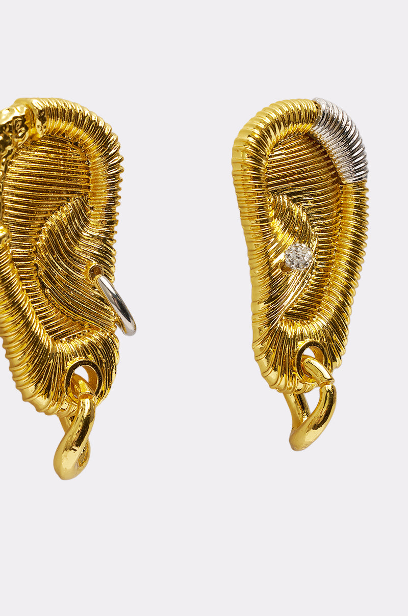 The HEARD U EARRING features gold, ear-shaped statement earrings with a textured coiled-wire design, mixed-metal accents in silver, and diamond-like details. The sculptural pair is displayed on a plain white background. 4