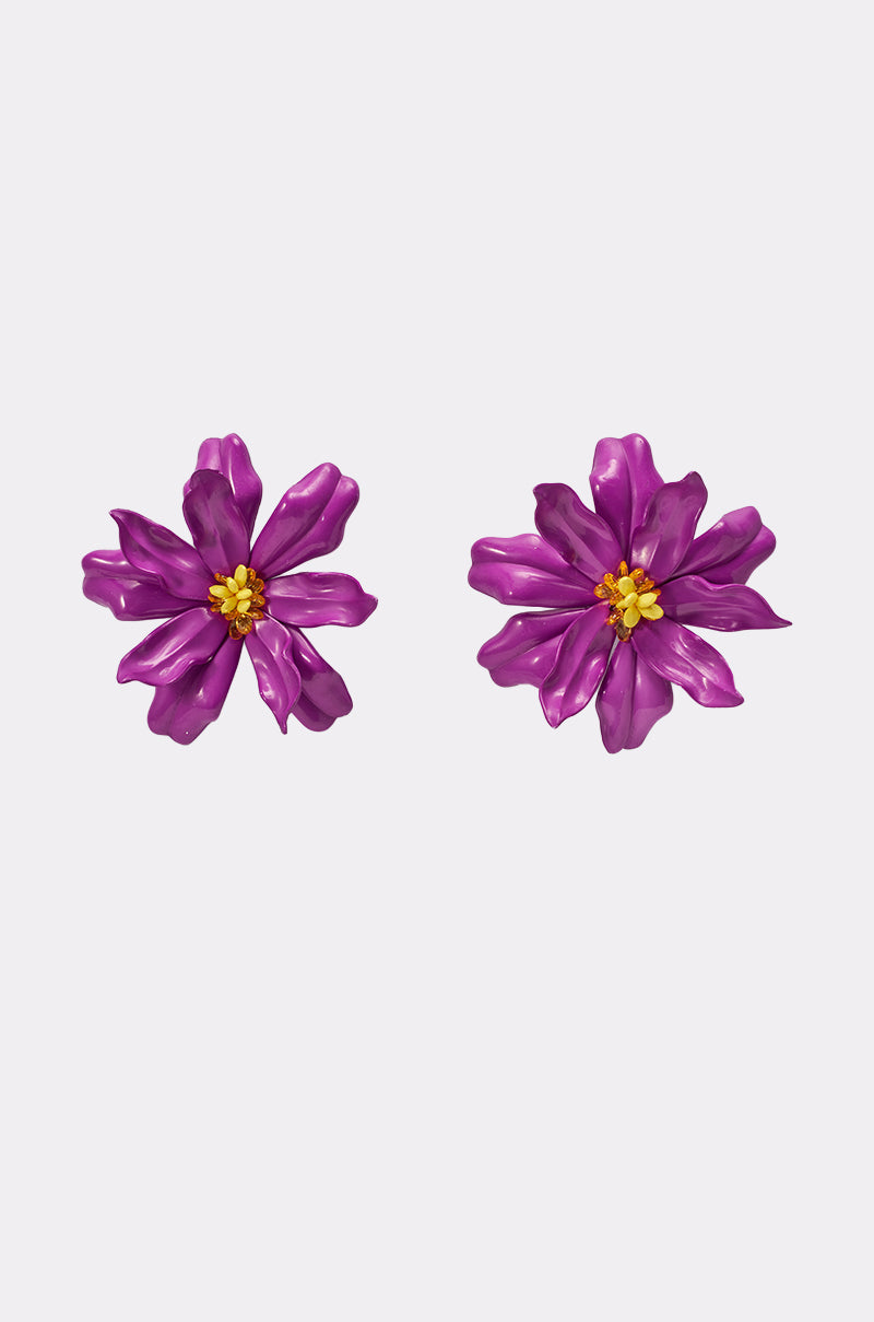 The IN THE GARDEN EARRING features two oversized petal earrings in a purple floral design with vibrant yellow centers, shown against a plain white background. 0