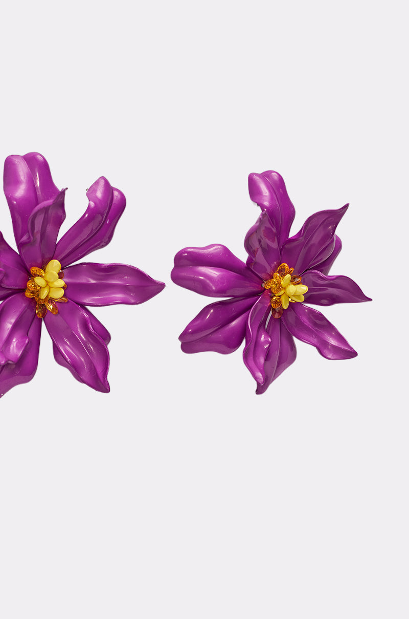 The IN THE GARDEN EARRING features two vibrant purple floral earrings with six glossy petals and yellow centers on a white background. Their bold, sculpted design makes them perfect for making a statement. 3