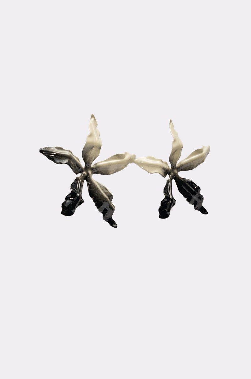 The TAKE A TRIP EARRING features oversized orchid-inspired petals with a cream-to-black gradient, set on a crisp white backdrop—perfect statement floral earrings to make an impression. 2