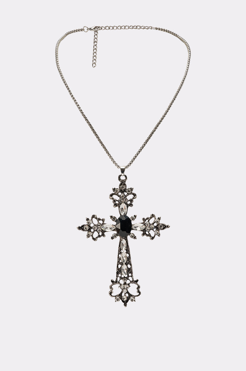 The KIM NECKLACE is a silver chain cross necklace with a large, ornate pendant highlighted by intricate patterns, sparkling rhinestones, and a bold black center gem—a stunning dark-romantic jewelry piece. 0