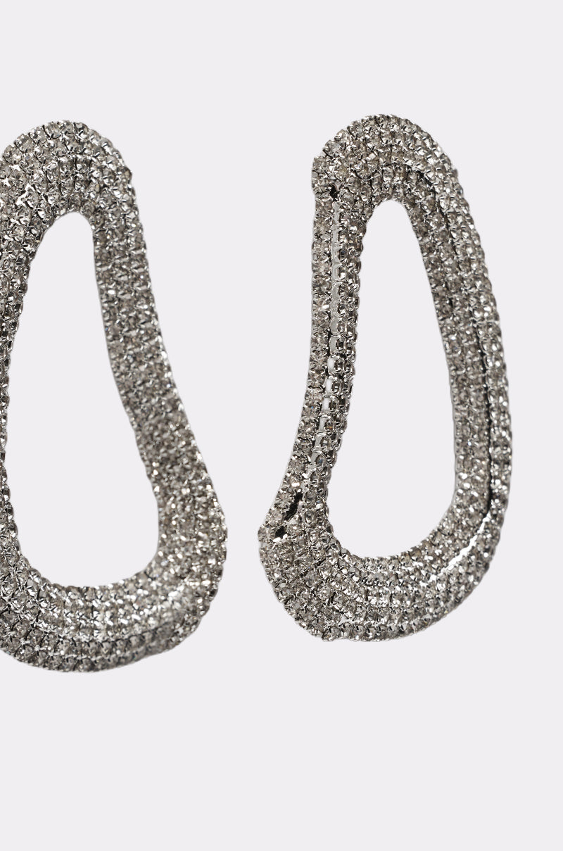 The GALA EARRING is a pair of silver-tone, teardrop-shaped earrings adorned with sparkling rhinestones, shown against a plain white background. 3