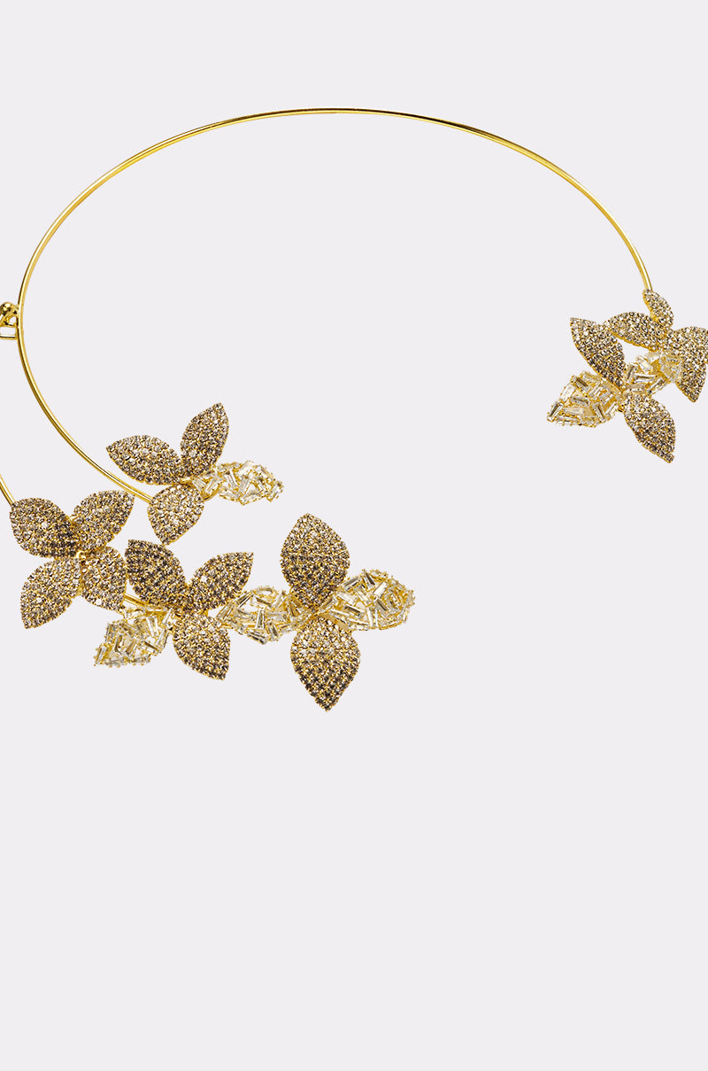 The IN BLOOM NECKLACE is a gold-tone collar necklace with intricate floral designs on each end, sparkling stones, and delicate leaf-shaped accents for an elegant rhinestone floral look. 3