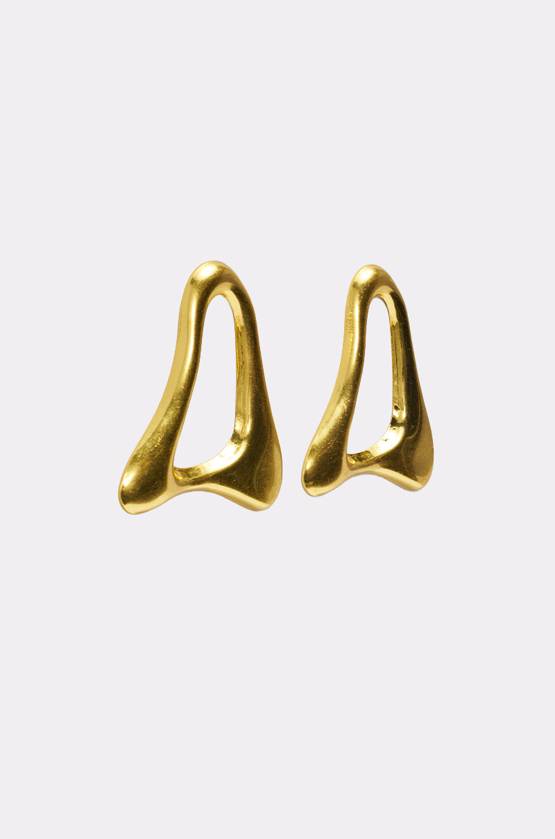 The MOD GAL EARRING is a pair of abstract, gold-toned sculptural earrings featuring smooth organic shapes with open centers, shown on a simple light gray background. 3