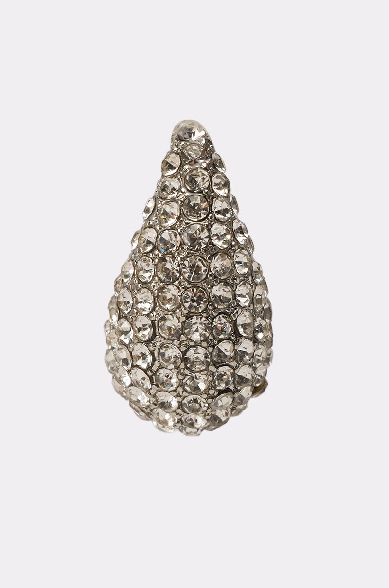 The DROPS OF JUPITER EARRING IN SILVER features a sculptural teardrop design covered in small, sparkling clear rhinestones set in a silver metal base, shown against a plain white background. 4
