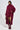 A woman wearing a burgundy sweater dress complemented by the PINKY PROMISE SOFT KNIT CARDIGAN, along with glossy knee-high boots. She holds a small clutch while standing against a plain background.