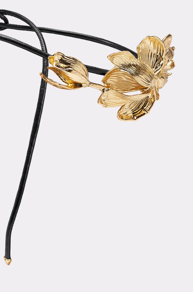 The PETAL POWER METAL DETAIL BELT, featuring intricate floral metal designs on a slim black band, stands out as a statement accessory, elegantly set against a light gray background. 4