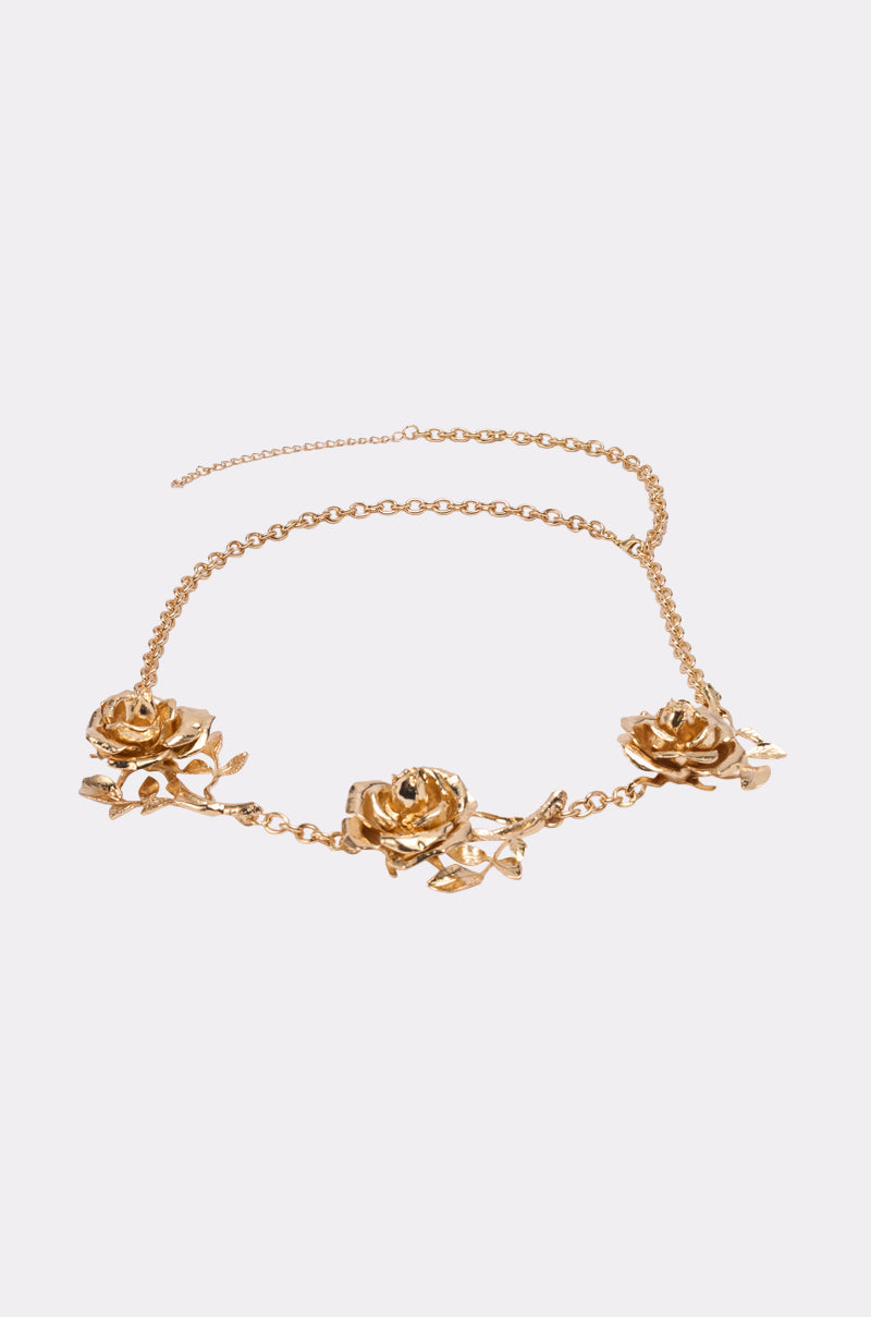 The LIKE A ROSE CHAIN BELT is a gold-tone accessory with three detailed rose medallion charms and leaf accents, showcased on a light background. 2