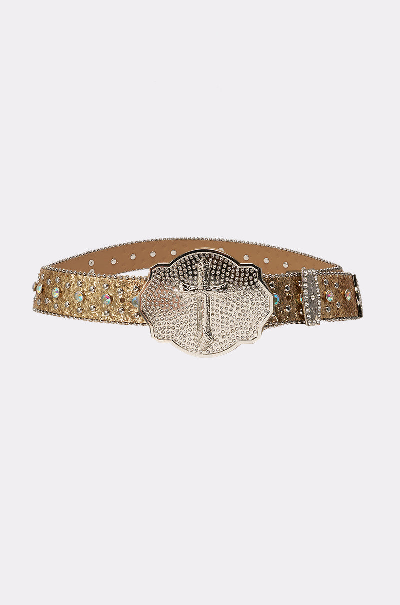 The BIGGER IS BETTER BELT is a gold glitter western belt with rhinestone accents and a large, ornate silver cross buckle for bold style. 1