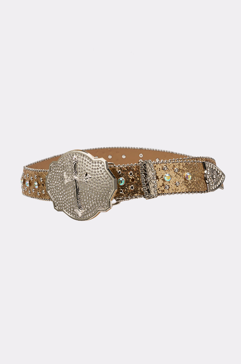 The BIGGER IS BETTER BELT is a gold glitter western belt with rhinestones, a cross-engraved buckle, silver tip, and detailed accents—perfect for making a bold fashion statement. 2