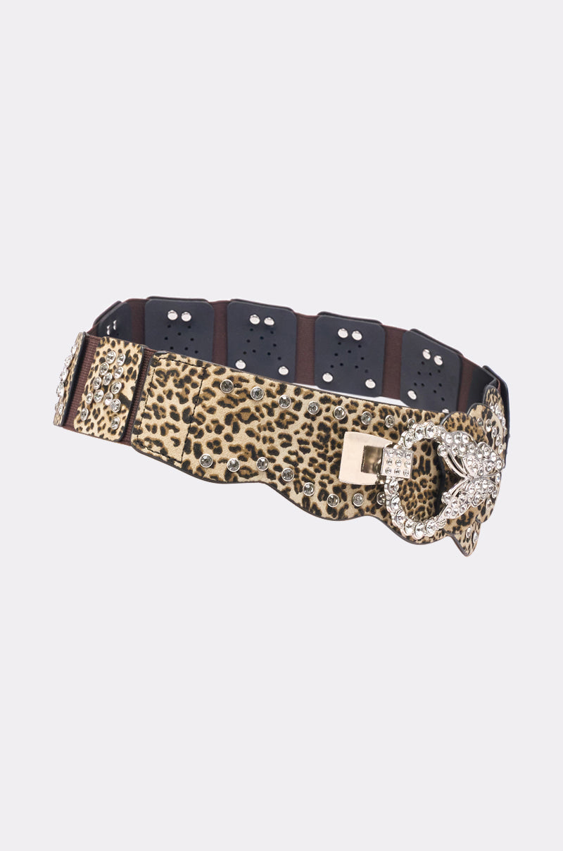 The CHANGE NOTHING BELT is a wide, stretchy leopard print belt featuring a unique silver buckle with gold accents, eyelet details, and an eye-catching design. 3