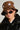 A person wearing the WEAR MY STARS CHEETAH BUCKET HAT, oval-shaped dark sunglasses, hoop earrings, and a black leather jacket gazes directly at the camera against a neutral background.